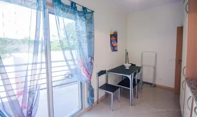 a room with a table and a window with a desk at Apartament Encosta Da Orada in Albufeira