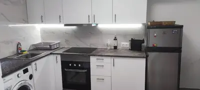 a kitchen with white cabinets and a stove and a refrigerator at Albufeira New House in Albufeira