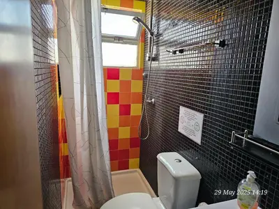 a bathroom with a toilet and a shower at Blife Bandaya private rooms at Faro beach in Faro