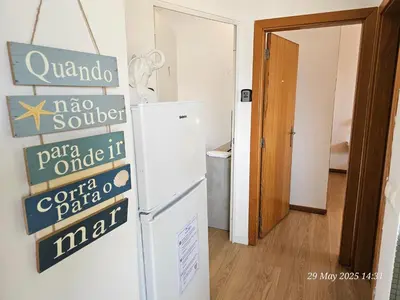 a refrigerator in a room with a sign on the wall at Blife Bandaya private rooms at Faro beach in Faro