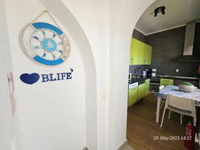 a kitchen with a clock on the wall at Blife Bandaya private rooms at Faro beach in Faro