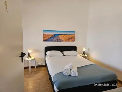a bedroom with a bed with towels on it at Blife Bandaya private rooms at Faro beach in Faro