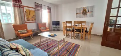 a living room with a couch and a table and chairs at Manu's Place in Albufeira