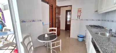 a small kitchen with a table and a sink at Manu's Place in Albufeira