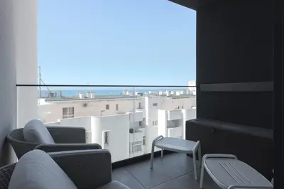 a balcony with chairs and a view of a building at Terracos de Quarteira II Pearl by Real Properties in Quarteira