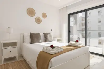 a white bedroom with a bed with towels on it at Terracos de Quarteira I Aqua by Real Properties in Quarteira