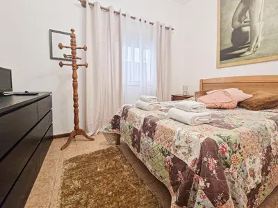 a bedroom with a bed with a dresser and a television at Casa Bacalhau - Tunes - Jacuzzi - BY BEDZY in Tunes