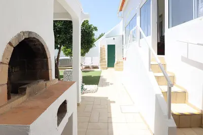 an empty sidewalk next to a building with an archway at Casa Bacalhau - Tunes - Jacuzzi - BY BEDZY in Tunes