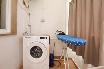 a laundry room with a washing machine and a stool at Casa Bacalhau - Tunes - Jacuzzi - BY BEDZY in Tunes