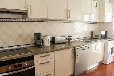 a kitchen with white cabinets and a counter top at Alta Oura 2 in Albufeira
