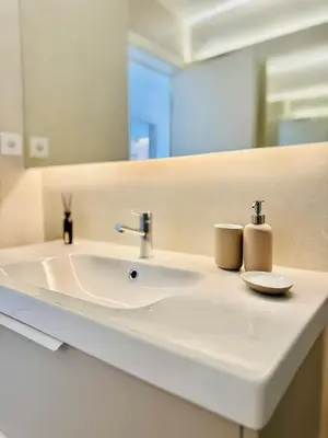 a bathroom with a sink and a mirror at Casa do Largo - Quarteira Algarve in Quarteira