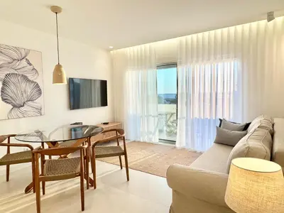 a living room with a table and a couch at Casa do Largo - Quarteira Algarve in Quarteira