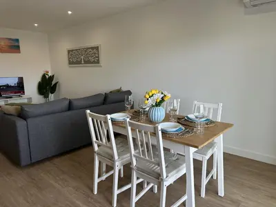 a living room with a table and a couch at Âncora Mar by FHR in Quarteira