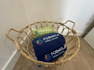 two pillows in a basket on a wooden floor at Âncora Mar by FHR in Quarteira