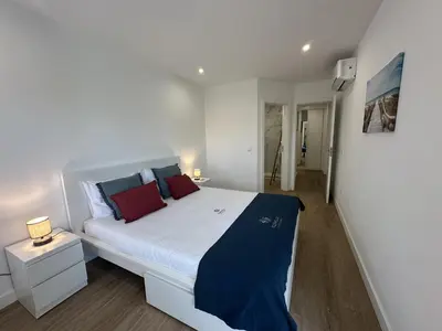 a bedroom with a large white bed with red pillows at Âncora Mar by FHR in Quarteira