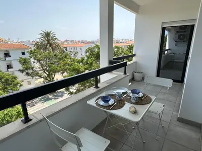 a balcony with a table and chairs and a view at Âncora Mar by FHR in Quarteira