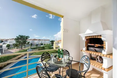 a balcony with a table and chairs and a pool at Apartment 1A Gale Garden by Algarve Villa Holidays in Albufeira