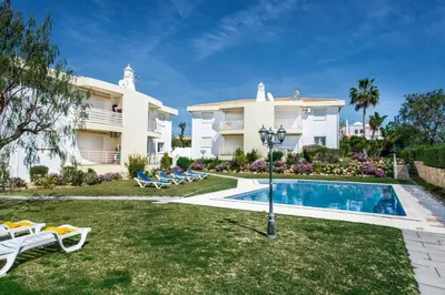 a villa with a swimming pool in front of a house at Apartment 1A Gale Garden by Algarve Villa Holidays in Albufeira