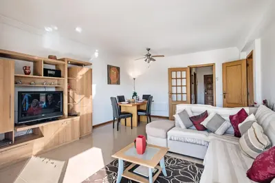 a living room with a white couch and a tv at Apartment 1A Gale Garden by Algarve Villa Holidays in Albufeira
