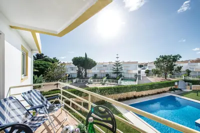 a balcony with chairs and a swimming pool at Apartment 1A Gale Garden by Algarve Villa Holidays in Albufeira