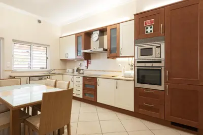a kitchen with a table and a dining room at Praia Village III - Peaceful condominium by HD in Quarteira
