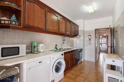 a kitchen with a washer and dryer on a counter at Beachfront Apartment T2 in Quarteira