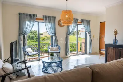 a living room with a couch and a tv at Rosemary Apartment in Olhos de Água