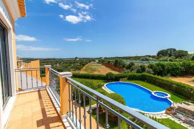 a balcony with a view of a swimming pool at Rosemary Apartment in Olhos de Água