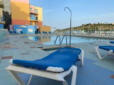 a blue lounge chair next to a swimming pool at Marina Albufeira Best Apartment in Albufeira