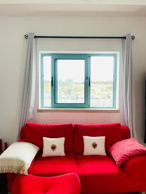a red couch in a room with a window at Marina Albufeira Best Apartment in Albufeira
