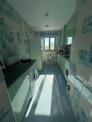 a small kitchen with a washer and a refrigerator at Marina Albufeira Best Apartment in Albufeira