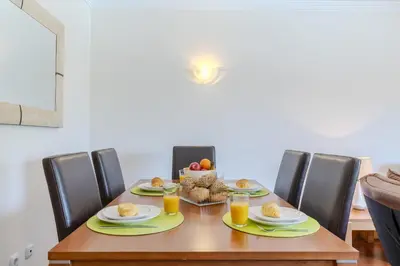 a dining room table with a bowl of fruit on it at #327 Corcovada 43 Vista Piscina by Home Holidays in Albufeira