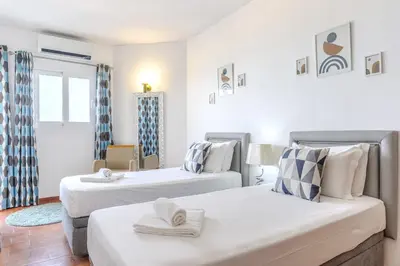 two beds in a room with white walls at #326 Vista Mar by Home Holidays in Albufeira