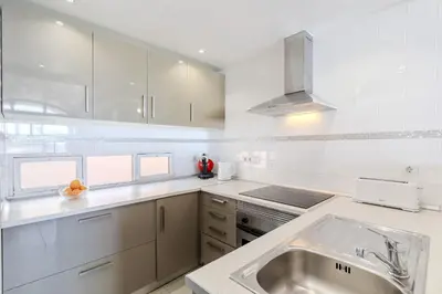 a white kitchen with a sink and a stove at #326 Vista Mar by Home Holidays in Albufeira