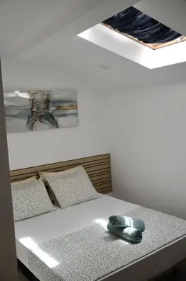 a bedroom with a bed with a phone on it at Train Station Guesthouse in Faro
