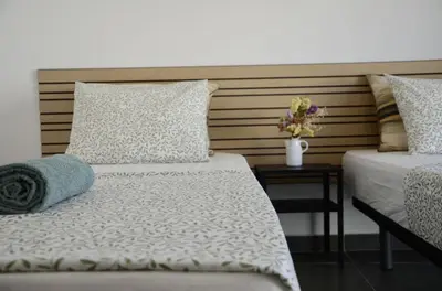 a bedroom with two beds and a table with flowers at Train Station Guesthouse in Faro