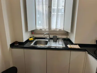 a kitchen counter with a sink and a window at Train Station Guesthouse in Faro