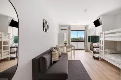 a living room with a couch and a room with bunk beds at The Oura Stay in Albufeira