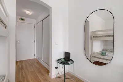 a mirror on a wall next to a table with a television at The Oura Stay in Albufeira