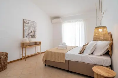 a bedroom with a bed and a table at Alma Invicta Albufeira in Albufeira