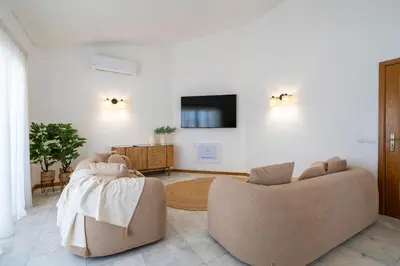 a living room with two chairs and a tv at Alma Invicta Albufeira in Albufeira