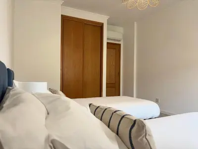 a bedroom with two beds and a chandelier at SummerSalt Apartment - Albufeira Old Town in Albufeira