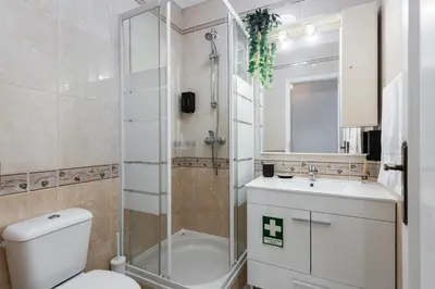 a bathroom with a toilet and a shower and a sink at Modern 2BR Quarteira Apartment in Quarteira