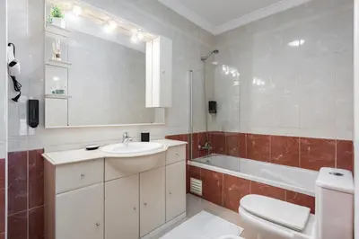 a bathroom with a sink and a toilet and a tub at Modern 2BR Quarteira Apartment in Quarteira