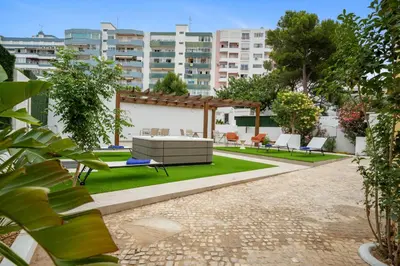 a backyard with chairs and a swimming pool at Urban Bliss Boutique Guesthouse in Faro