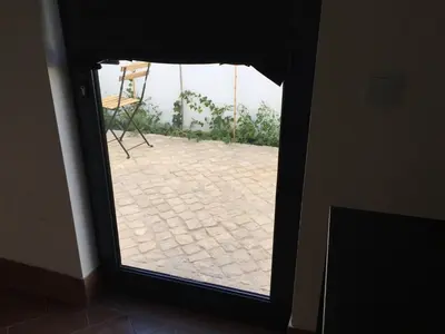 a door with a view of a patio through a window at Pátio da Várzea in Albufeira