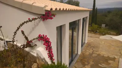 a white building with flowers on the side of it at B&B Casa Encantada in Boliqueime