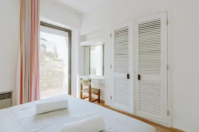 a white bedroom with a bed and a window at Apartment Green Oasis in Albufeira Jardim mit Pool in Albufeira