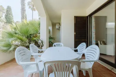 a white dining room with white chairs and a table at Apartment Green Oasis in Albufeira Jardim mit Pool in Albufeira