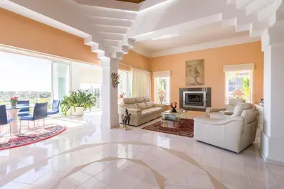 a living room with white furniture and a fireplace at Traumhaft schöne Villa mit Pool und Meerblick in Albufeira